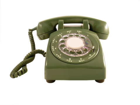 A straight on shot of a retro phone isolated on a white background.  Room for copy in the middle of the dial.