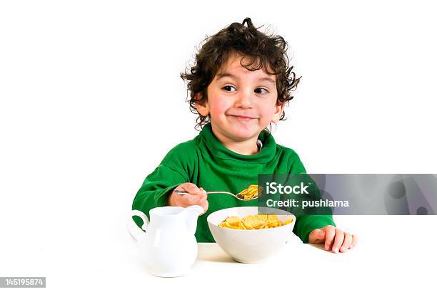Young Boy With A Green Sweatshirt Eating Cornflakes Stock Photo - Download Image Now