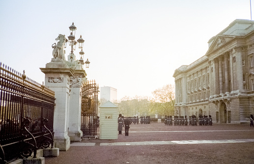 London, UK - 26 March 2022: The Dominion Gate entrance to Buckingham Palace, London, with coat of arms and ornate lanterns. Residence to Queen Elizabeth II, who has reigned for 70 years.