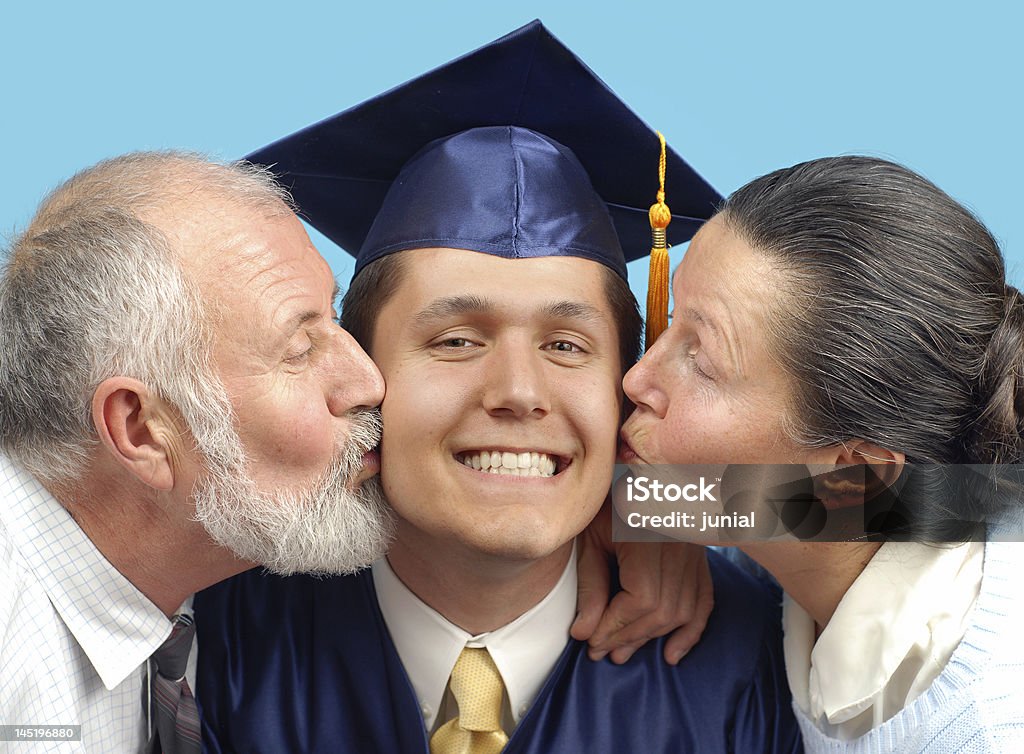 Kissing the new graduate Proud parents kissing their graduating son on both cheeks Graduation Stock Photo