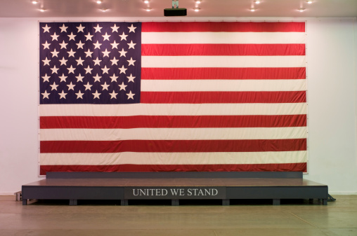 Large USA American wall flag draped behind presentation stage
