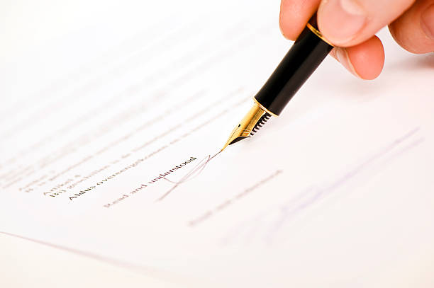 read and understood signature someone signing a document with a pen.  Text is blur, only ""read and understood"" is visible. Isolated on white background. read and understood stock pictures, royalty-free photos & images