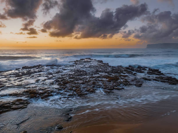 istock Surfs up sunrise at the seaside with scattered clouds 1451989748