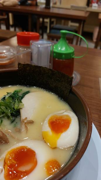 half boiled egg on top of a bowl of ramen noodles