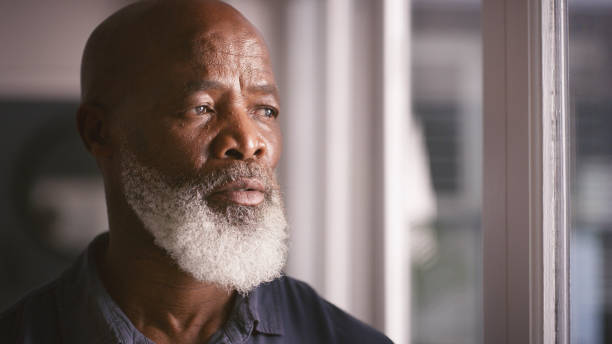 istock Black man, thinking and senior looking out window with retirement, future and memory on mind at home. Face of old person in house to relax while planning pension for life insurance or investment 1452001862