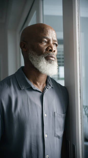 istock Sad, thinking and depression with black man at window problem, lonely and lost crisis at home. Anxiety, stress and mental health trauma with old man feeling burnout from drama, worry and failure 1452002009