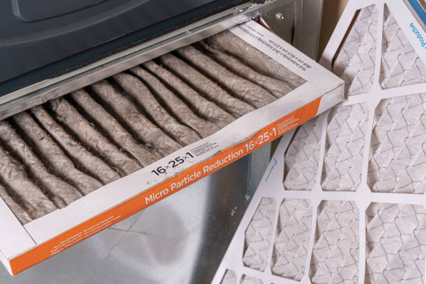 Replacing dirty furnace filter in home stock photo