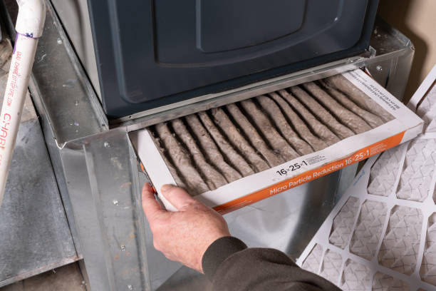 hombre reemplazando el filtro del horno sucio en casa - air duct cleaning air conditioner furnace fotografías e imágenes de stock