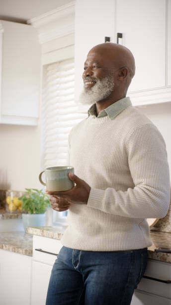 istock Senior black man, relax and drink coffee in kitchen thinking or happy memory u home. Elderly african man, smile and retirement vision, drinking tea and relaxation or happiness mindset in. morning 1452015244