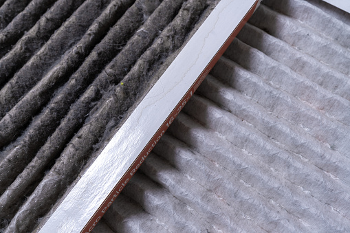 Close-up of furnace filters that are dirty and clean