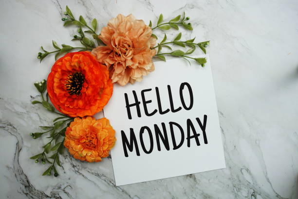 istock Hello Monday text with orange flower bouquet on marble background 1452016291