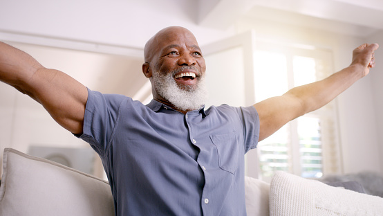 Black man watch sports, elderly and happy with win, celebrate team winning in World Cup match. Winner, sport fan and watching soccer during retirement, celebration and happiness with game results