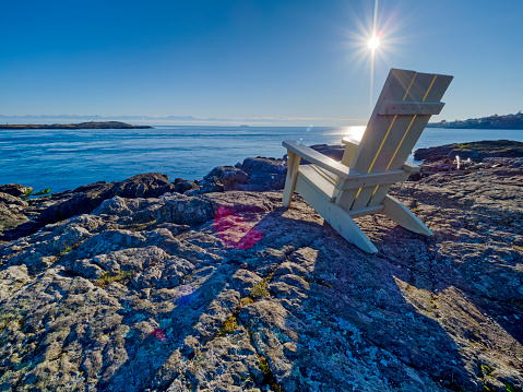 Adirondack chair and view of the Strait of Juan de Fuca along the coastline of Victoria,  British Columbia