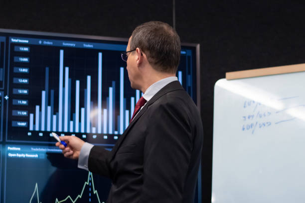 istock Back view of financier analyzing market reports 1452023130