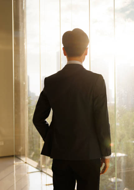 istock Businessman looking at city skyline through office window 1452024247
