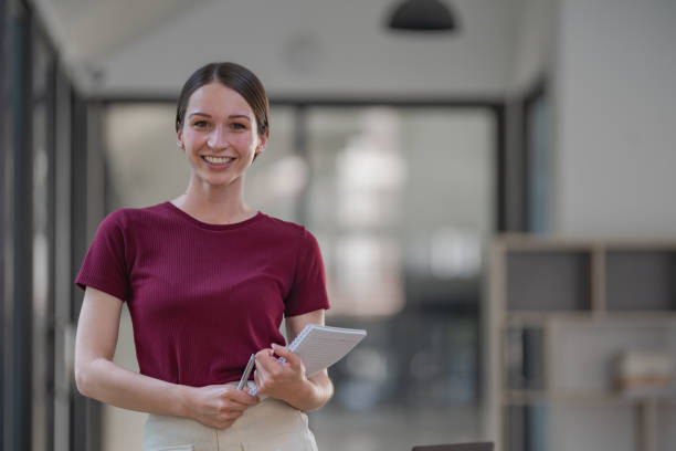 istock Attractive businesswoman standing and thinking while holding a pen and a notebook. 1452030956