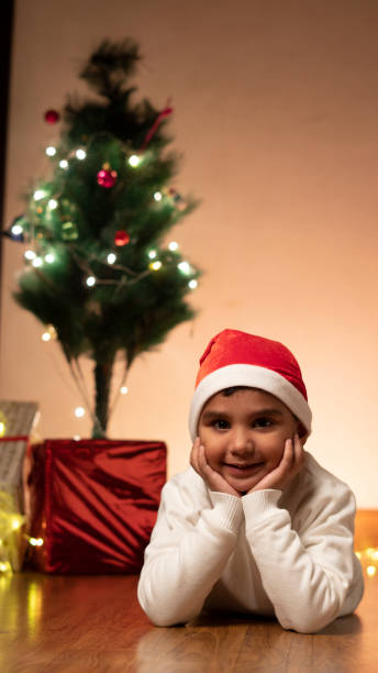 istock Happy Indian child boy wearing santa cap,christmas tree 1452030998