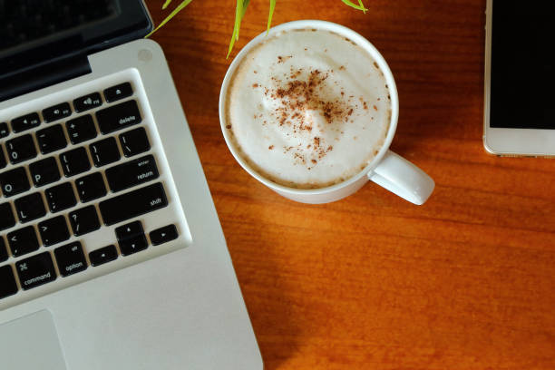 hot latte em copo na vista da mesa de madeira de cima com laptop e smartphone ao redor e tem espaço de cópia. - hot chocolate hot drink high section color image - fotografias e filmes do acervo