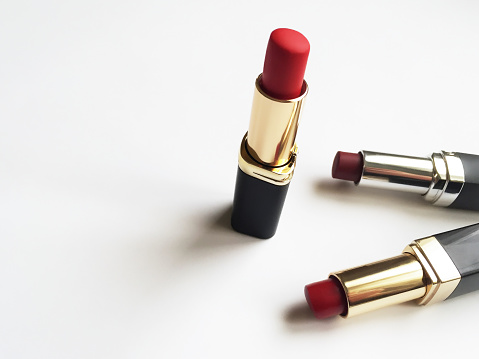 Multi colored group of lipsticks on the white background with copy space