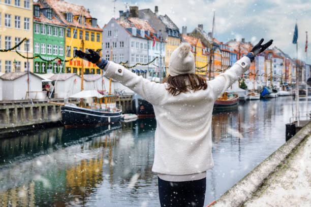 a happy tourist woman enjoys the winter view of the nyhavn area in copenhagen - white denmark nordic countries winter imagens e fotografias de stock