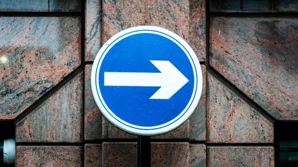 One way street sign in front of an office building