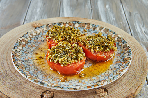 Provence tomatoes on plate on wooden background.