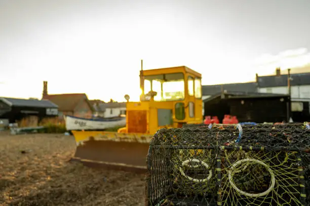 Photo of Shallow focus of empty lobster pots seen during dusk on a Suffolk beach.