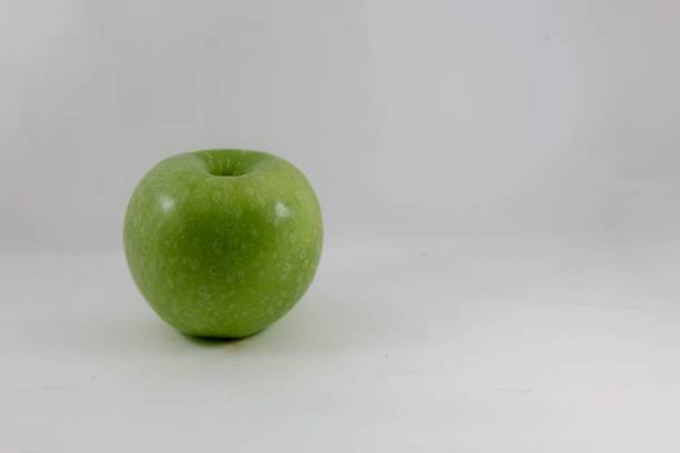 A tasty green apple on a white background