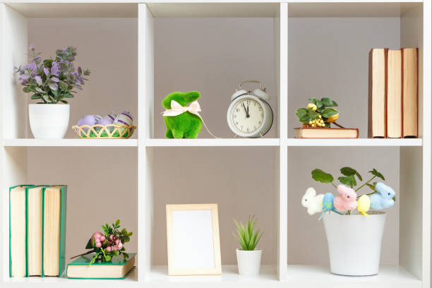 istock Home interior, elements of Easter decor. White shelves with books photo frame rabbits eggs 1452085611