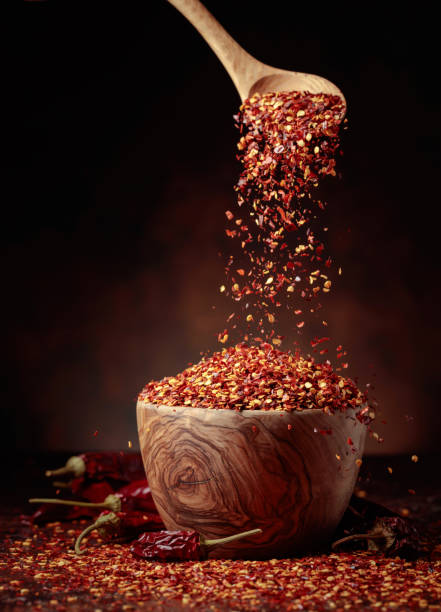istock Chilli flakes are poured into a wooden dish. 1452092799