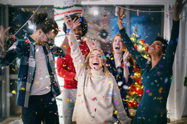 New year party. Friends celebrating the New Year together. The confetti are falling and everyone is excited. Happy New Year!!!  New Year  Party stock pictures, royalty-free photos & images