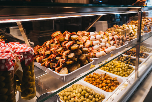 Madrid,Spain,15th December 2022 - Locals and tourists enjoying fresh food and snacks and drinks inside San Miguel food market in central Madrid, with multiple cafes and food shops available in one place. San Miguel is one of the most popular attractions for visitors to Madrid.