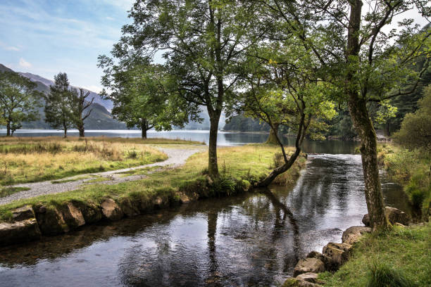 The cool, clear water of the River Derwent flows south from Derwent Water on a bright crisp spring morning.