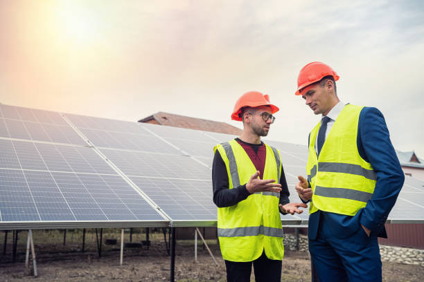 istock tall men in work clothes are considering whether to install solar panels in the open air. 1452113409