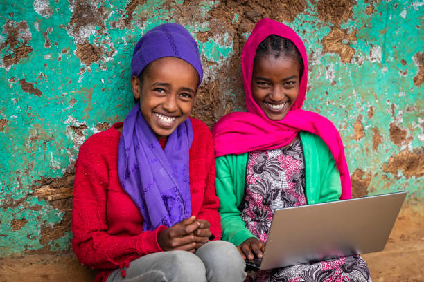 chicas jóvenes africanas usando computadora portátil, áfrica oriental - africa child village smiling fotografías e imágenes de stock