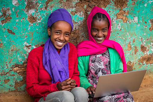 Young African girls using laptop in the village in Central Ethiopia, Africa.