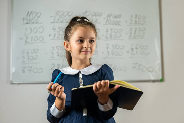 istock fleeting student stands by the blackboard with her notebook to see where to take an example. 1452117810