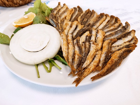 Traditional turkish fried hamsi anchovy fish dish with rocket and onion at Istanbul turkey
