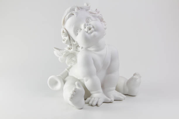 white figurine of a small cherub angel sitting. High quality photo
