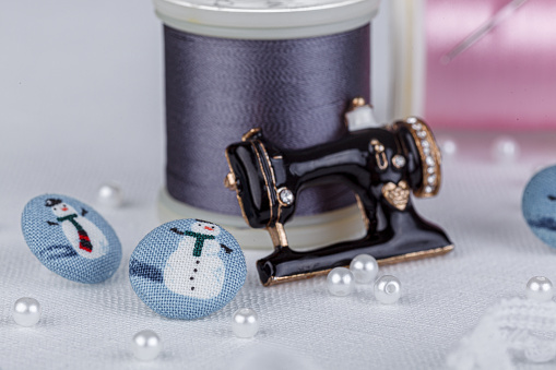 still life of a skein of thread for sewing, needles, buttons, sewing machine on a white background close-up