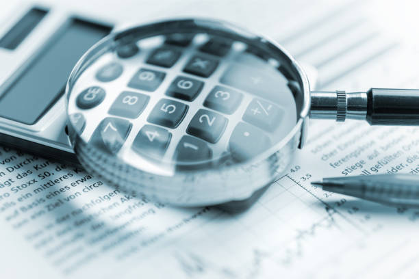 istock Magnifying glass, calculator on paper 1452131702