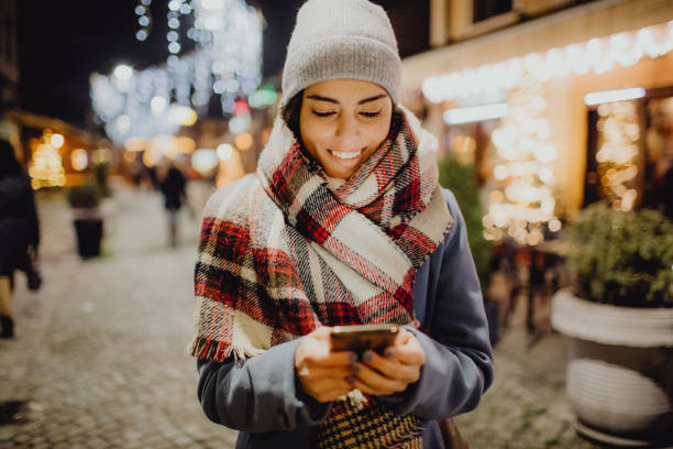 istock A smiling woman enjoying winter holidays while using her smartphone outdoor 1452132720