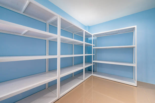 istock Empty white shelves in blue storage room 1452137304