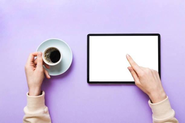 istock Close up image woman hands holding digital tablet with blank copy space screen for your text message or promotional content om table with cup of coffee. hands of a woman holding blank tablet device 1452137494