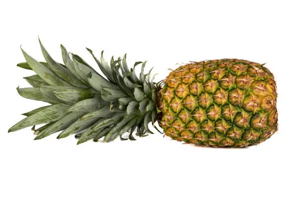 Photo of Ripe whole pineapple horizontally on a white background.