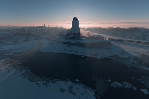 Aerial panorama of the historical center of Vyborg in winter. View of the castle island and the Gulf of Finland. Dramatic light.