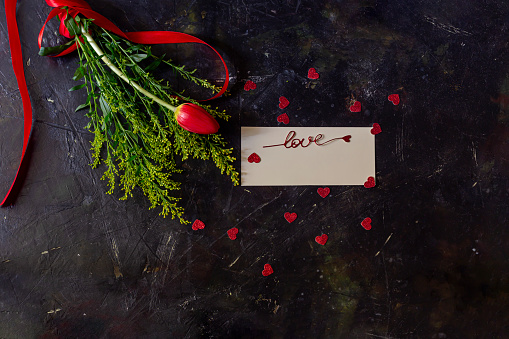 Composition for Valentine's Day, Women's Day or birthday. Romantic bouquet of red tulip on a wooden table close-up.