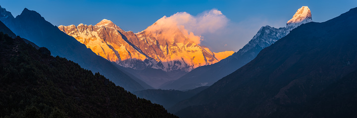 Mt. Everest, Nuptse, Lhotse and Ama Dablam illuminated by the golden light of sunset towering over the Khumbu Valley high in the Himalayan mountain wilderness of Nepal.