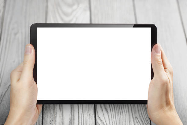 istock Hands holding black tablet on white wood 1452154722