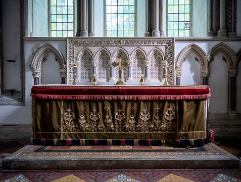 The high altar in the parish church of St Lawrence in Castle Rising, a pretty village in West Norfolk, Eastern England. The church is of Norman origin but was restored in the Romanesque style in the 19th century by Anthony Salvin and George Edmund Street. The village is very popular with tourists and contains a beautiful, historic castle.